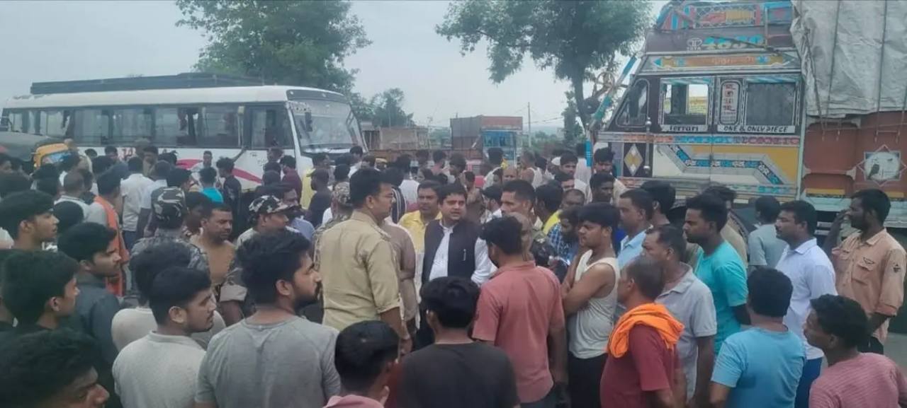 सड़क पर बस और ट्रक के पास जुटे ग्रामीण और स्थानीय लोग