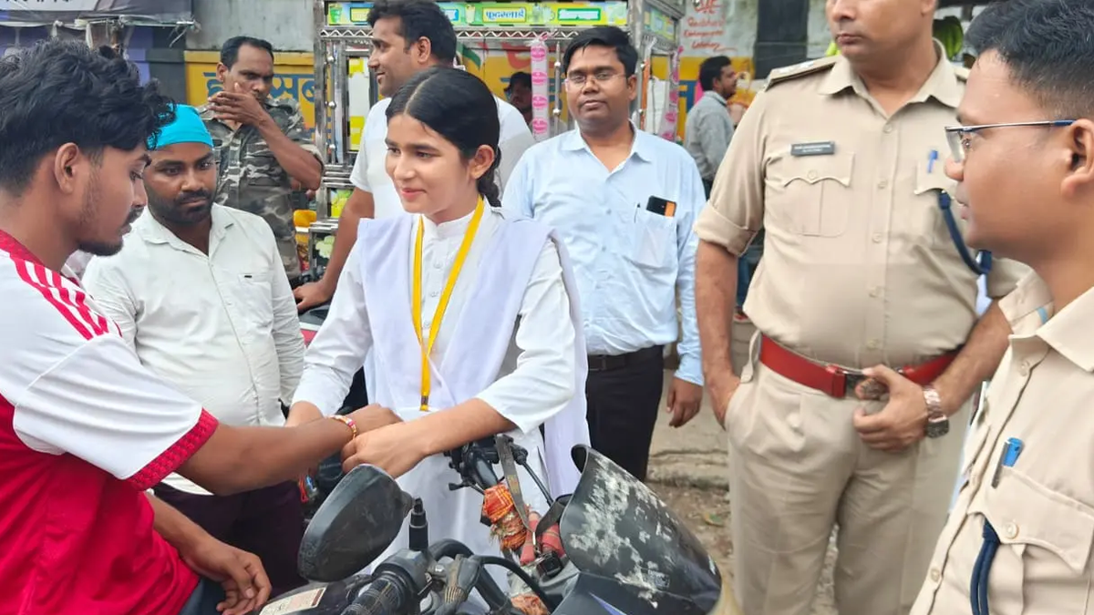 लातेहार के सड़क सुरक्षा अभियान में वाहन चालक को राखी बांधती छात्रा