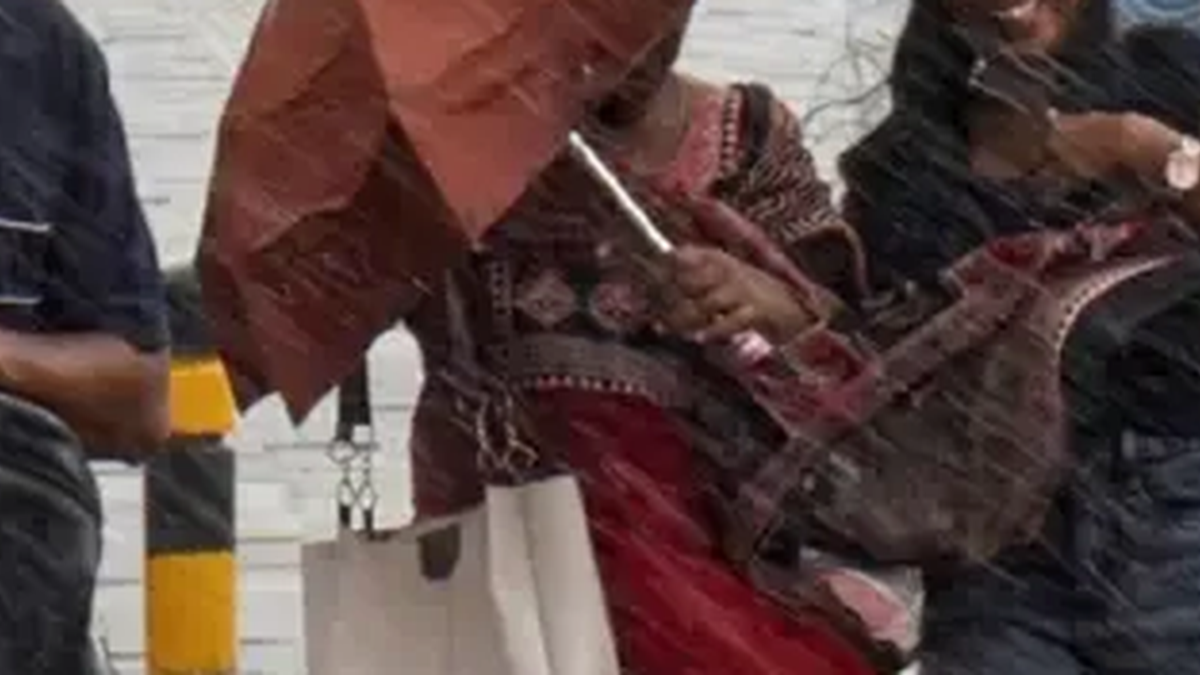 धनबाद में तेज बारिश के बाद जलमग्न सड़क से गुजरते वाहन