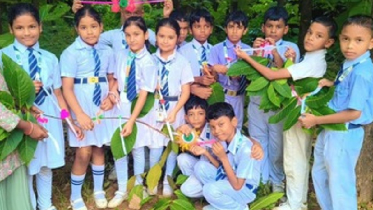 अशोका इंटरनेशनल स्कूल में तरू भ्राता कार्यक्रम के दौरान पौधों को राखी बांधते बच्चे