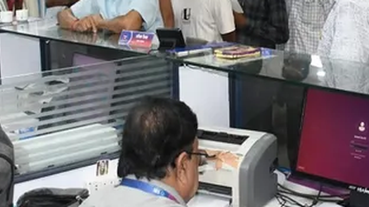 धनबाद की सरकारी बैंक शाखा में रविवार को पहुंचे ग्राहक और काली पट्टी बांधे कर्मचारी