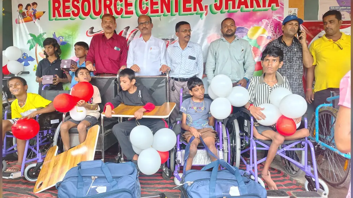 झरिया रिसोर्स सेंटर में दिव्यांग बच्चों को सहायक उपकरण वितरित करते लोग