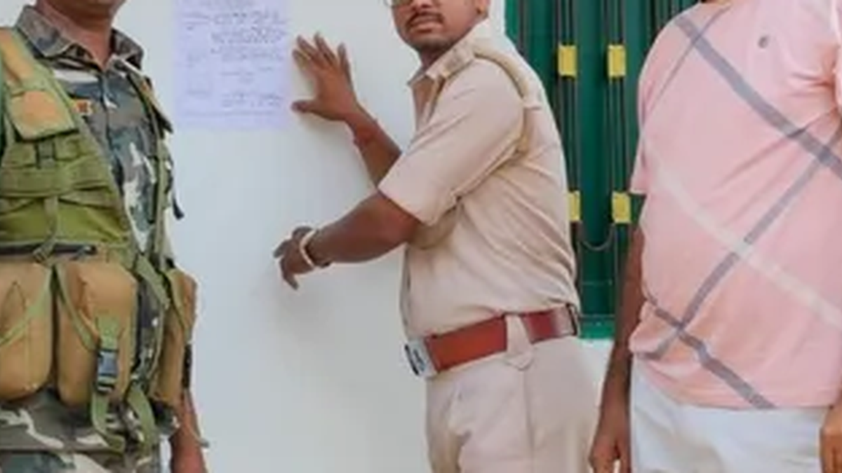 भोजपुर के सलेमपुर गांव में आरोपी के घर इश्तेहार चस्पा करती लातेहार पुलिस