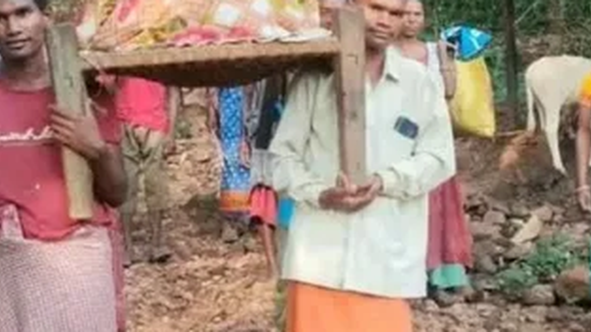 मुसाबनी के बोगासुतली टोला में गर्भवती महिला को खटिया से मुख्य सड़क तक ले जाते ग्रामीण