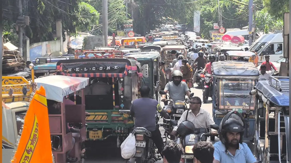 देवघर शहर की सड़क पर जाम में फंसे वाहन और स्कूल बसें