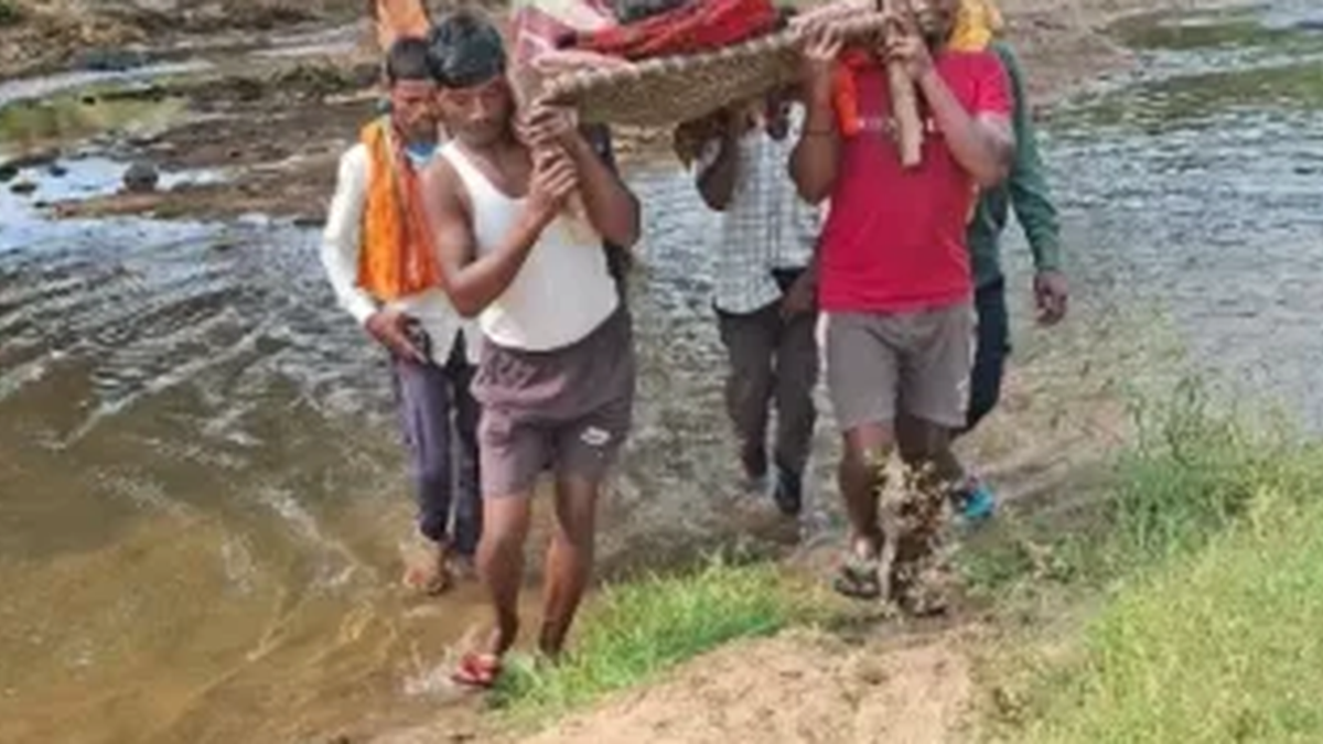 चतरा के बुटकुइया गांव में गर्भवती महिला को खाट पर मुख्य सड़क तक ले जाते परिजन और ग्रामीण