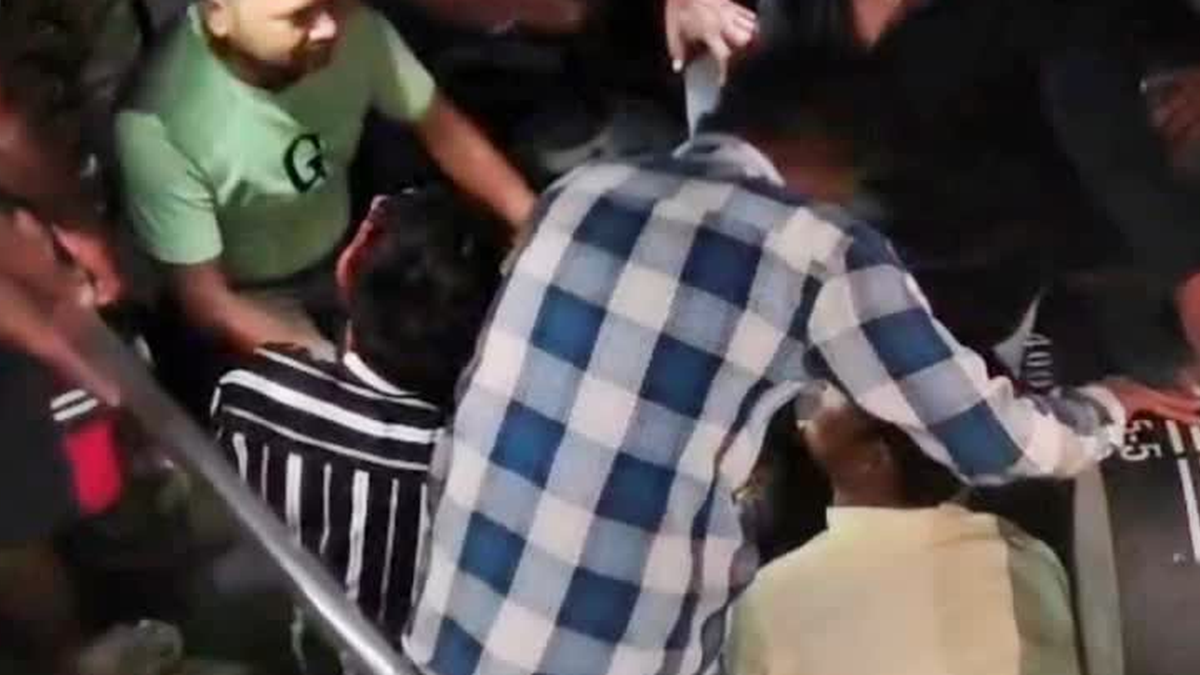 बेलगड़िया टाउनशिप में जलापूर्ति पाइप से बच्चे को निकालते पुलिसकर्मी और ग्रामीण