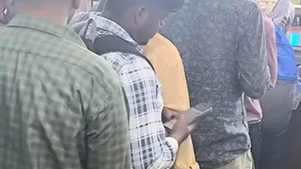 कोडरमा रेलवे स्टेशन के आरक्षण काउंटर पर टिकट के लिए कतार में खड़े यात्री